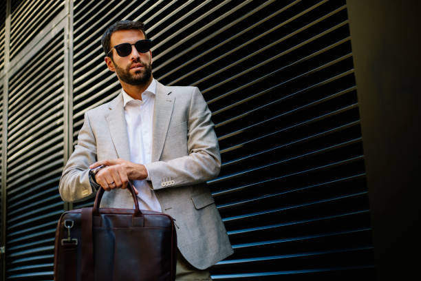 Handsome businessman in a hurry. Shallow DOF. Developed from RAW; retouched with special care and attention; Small amount of grain added for best final impression. 16 bit Adobe RGB color profile.