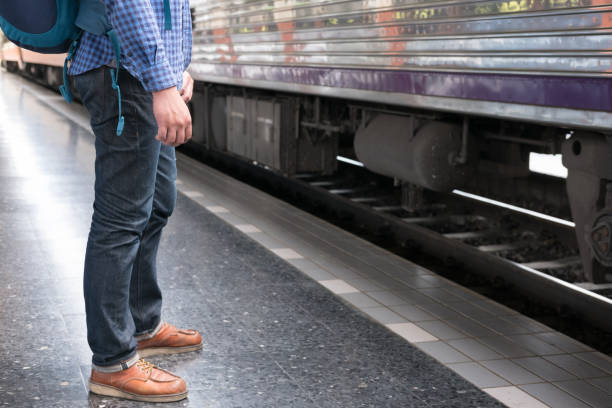 istock asian man with backpack standing on platform at train station. backpacker or traveler waiting for train. journey, trip, travel concept 821369776