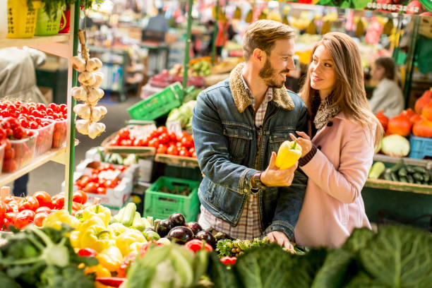 istock Young couple buying vegetables on a market 821375632