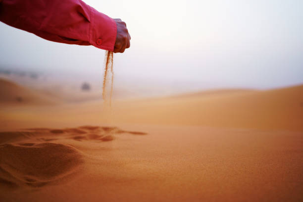 istock Woman sitting on sand in the desert 821403906