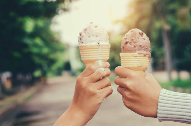 istock children's hands holding ice cream cone on summer light nature background 821407420