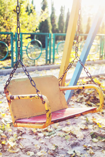 istock Empty children's swing in autumn park at sunset 821407590