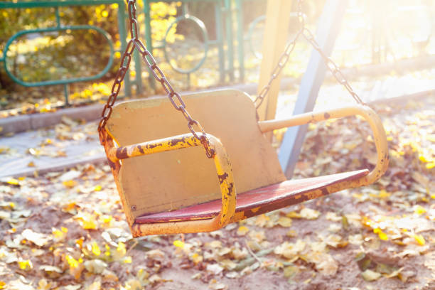 istock Empty children's swing in autumn park at sunset 821407606