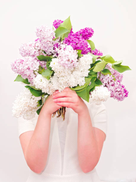 Girl with violet lilac flower on white background. Flat lay, top view