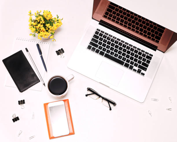 istock Workspace with laptop keyboard mobile phone coffee glasses flowers 821416158