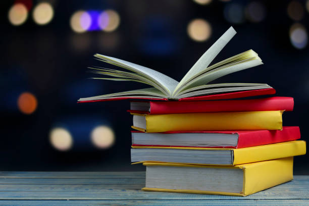 istock book on wood table and soft blur bokeh background, concept as opening paper will see knowledge of the world, learning by yourself and improve your life everywhere 821416390