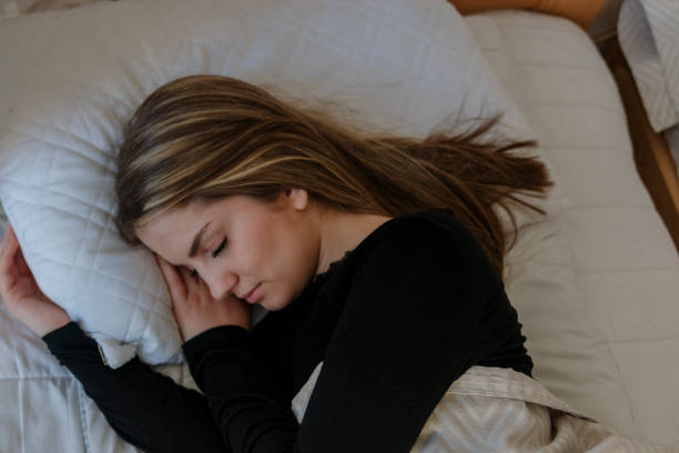 istock Young beautiful woman sleeping in bed under white blanket. 821422392