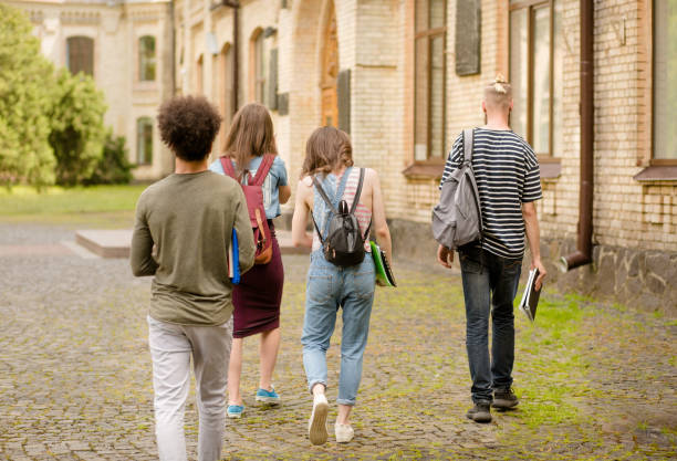 istock Rear view of young students going to college. 821426800