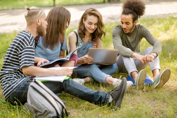 istock College friends sitting on lawn in campus, communicating. 821433038