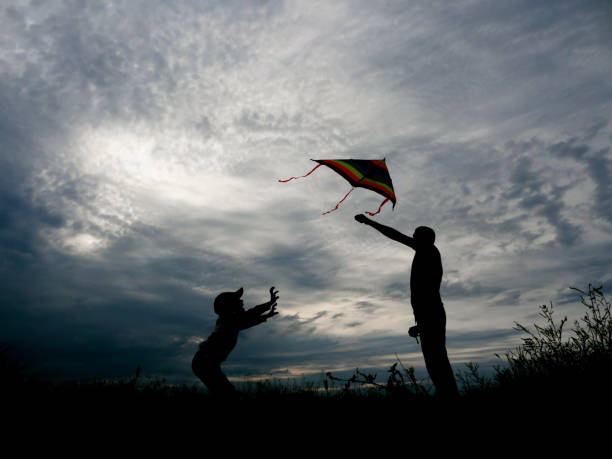 istock happy father and son launching a kite at sunset 821433870