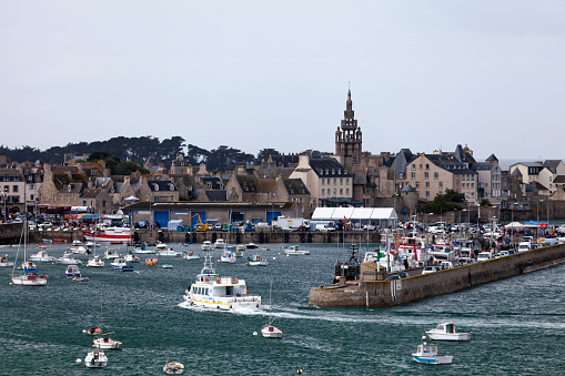 Roscoff, France - July 22 2017: Ferry from Batz Island entering the Port in Roscoff, with behind, the spire of the Église Notre-Dame de Croaz Batz.