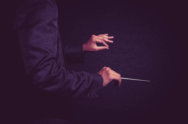 オーケストラ指揮者の手、暗い背景に棒を保持しているミュージシャン監督 - conductor leadership music conductors baton ストックフォトと画像