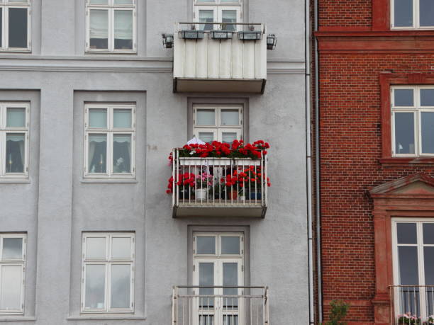 Red Flowers in Window Box at Balcony on Apartment Facade