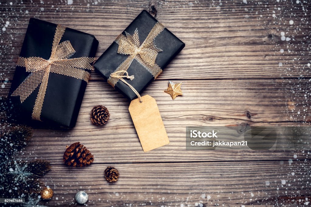 Christmas gift box with decoration Christmas background - Christmas present gifts box and rustic decoration on vintage wooden background with snowflake. Creative Flat layout and top view composition with border and copy space design. Above Stock Photo