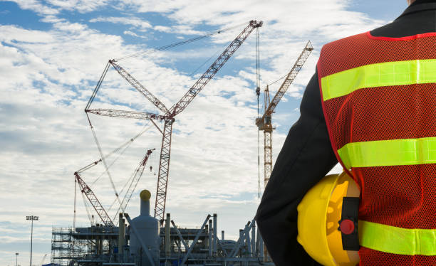 istock Hand or arm of engineer hold yellow plastic helmet 821457940