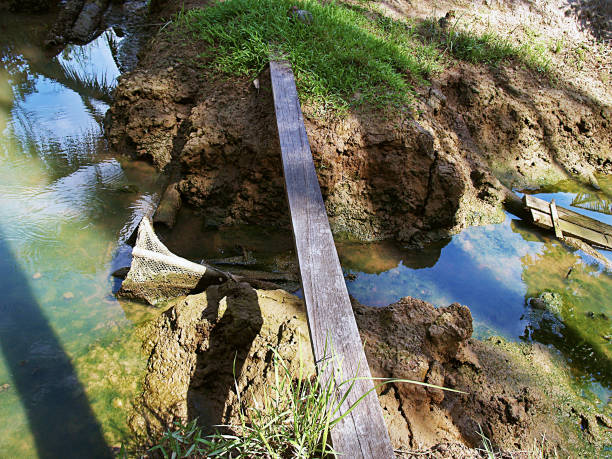 istock Small simple bridge of wood planks, over a small stream 821460796
