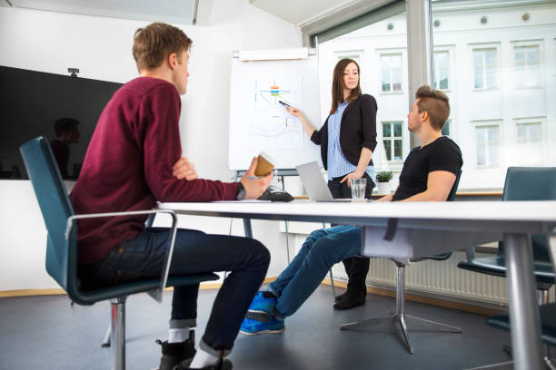 istock Businesswoman Explaining Graph To Coworkers In Office 821463778