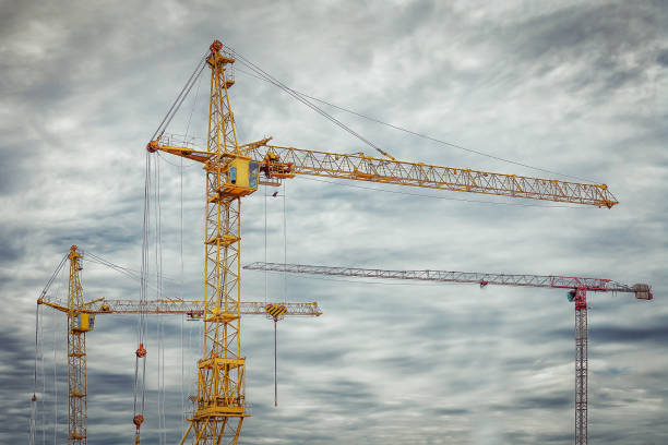 istock Industrial construction cranes against a gray cloudy sky with clouds. 821467132