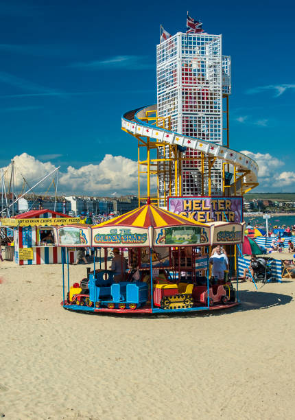 helter skelter et rond-point sur la plage de weymouth - skelter photos et images de collection