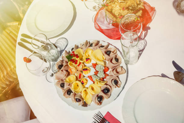 istock Sunlit cold plate with cheese and ham and fruit. Decorated table in the garden 821472614