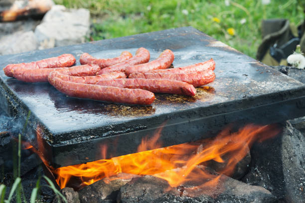istock Roasting sausages on the hot stone in nature 821475670