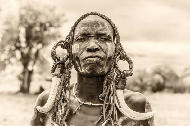 Warrior from the african tribe Mursi, Ethiopia Omo Valley: Warrior from the african tribe Mursi with traditional horns in Mago National Park, Ethiopia.  Vintage black and white processed. african tribe stock pictures, royalty-free photos & images