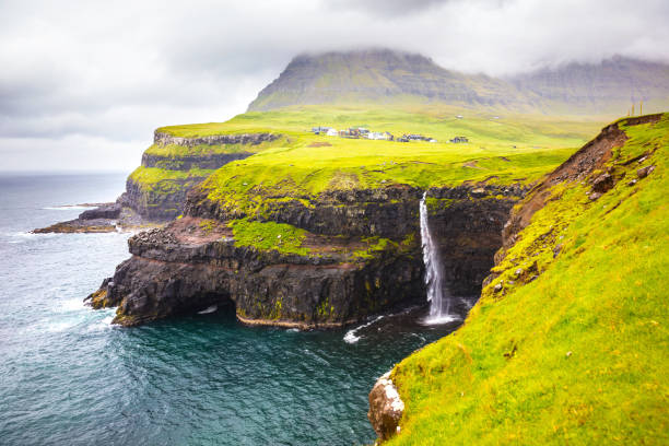 istock Dramatic waterfall on Faroe Islands and the village Gasadalur 821485438
