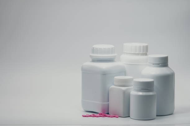 istock Pink tablet pills with closed bottles 821486506