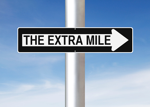 A modified one way sign indicating The Extra Mile