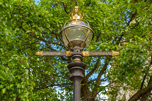 A lamppost in Northcote, Victoria, Australia featuring a glass dome light, and High Street name in gold lettering. Also featuring a golden Queen Elizabeth crown on top.