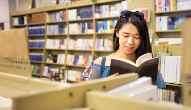 アジアの女の子は、本屋�で本を読んで - bookstore student chinese ethnicity book ストックフォトと画像