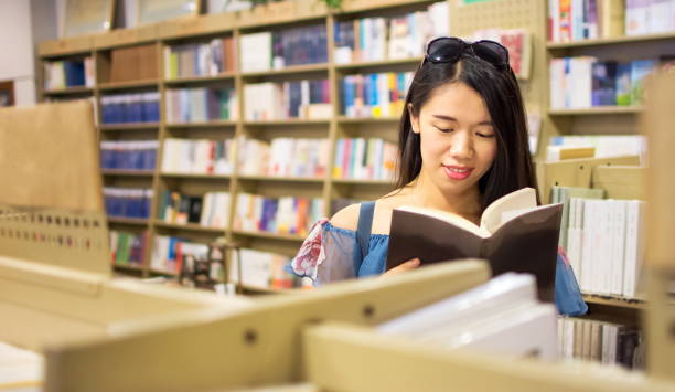 istock Asian girl reading in a bookstore 821497796