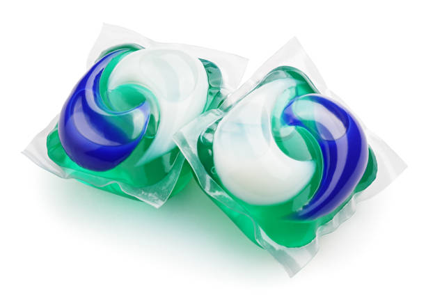 gel capsule pods with laundry detergent on white Two washing gel capsule pods with laundry detergent isolated on white background with clipping path detergent capsule stock pictures, royalty-free photos & images