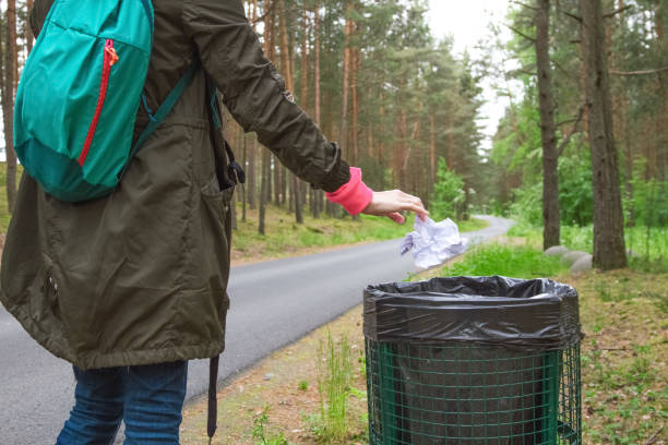 The modern woman throwing out garbage in basket .