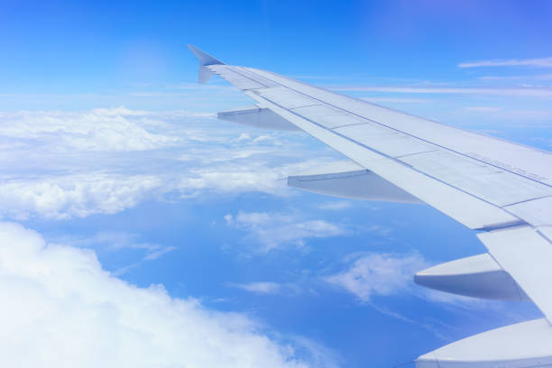 istock Looking thru airplane 's window seeing wing of airplane , white clouds and blue sky 821515978