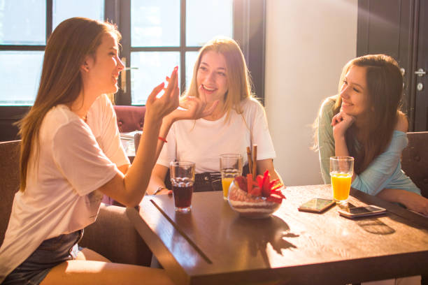 istock Three beautiful girls having fun in a cafe bar. 821521476