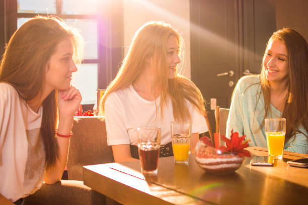 istock Three beautiful girls talking in a cafe bar. 821521544