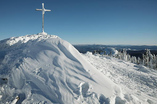 wooden cross on top of a mountain Maple covered with big frost. Grosser Arber, Bayerisch Eisenstein, Germany. Winter snowy summit of Mt. Grosser Arber at Bavarian Forest (Germany).