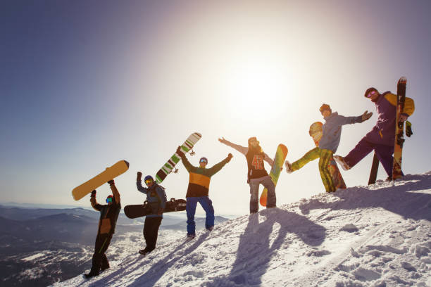 人のスノーボーダー、スキーヤー山夕日のグループ。冬の屋外スポーツ - snowboarding friendship snow winter ストックフォトと画像