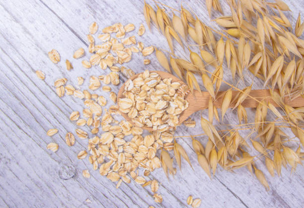 istock Raw oat flakes on a wooden table - closeup. 821540730