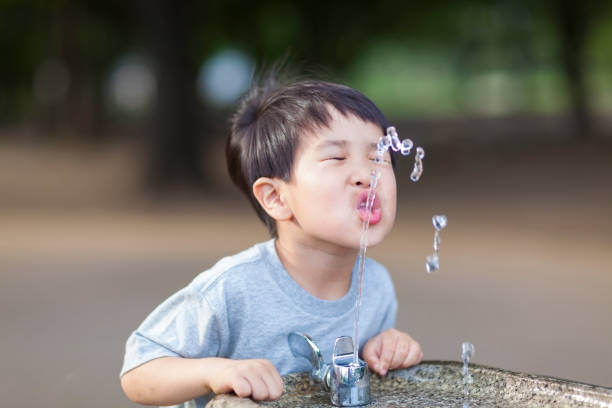 istock Boy Drinking Water From Water Fountain 821543380