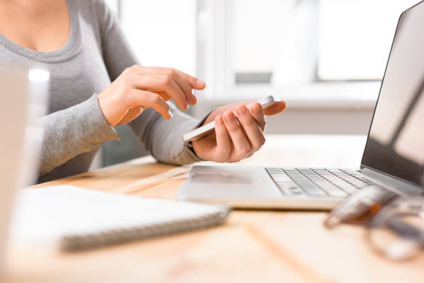 istock Hands working on the phone in front of the copmputer screen 821543986