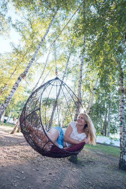 istock Romantic young woman riding on a hanging chair 821544794