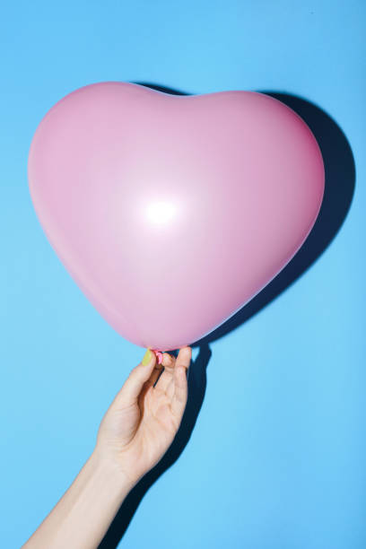 istock Pink heart shaped baloon for St Valentine's Day on blue 821547554