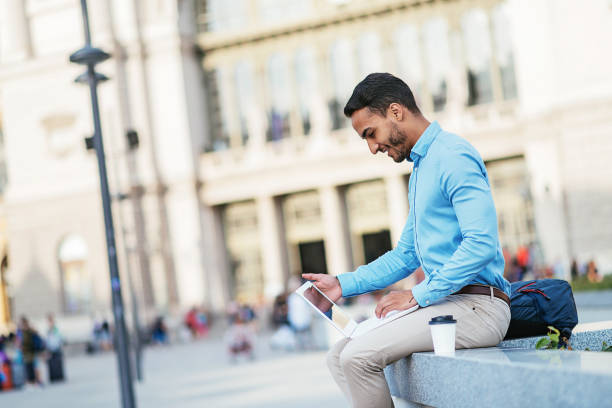 istock South American guy using laptop near University building 821552722