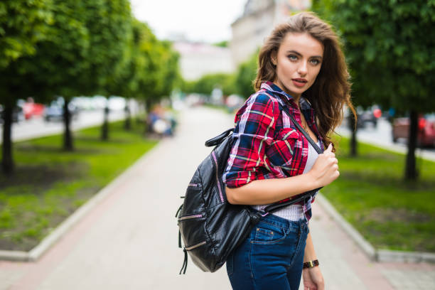 istock Young female student with backpack walking in the park 821558988