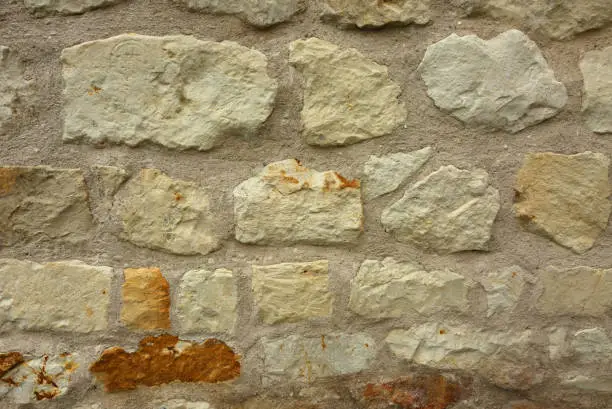 Old, porous stone wall as a very interesting background and texture. Horizontal view.
