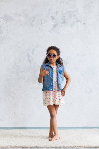 istock Cute afro girl against the gray wall 821561606