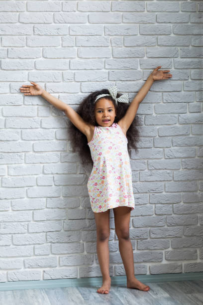 istock Cute afro girl against the gray wall 821562282