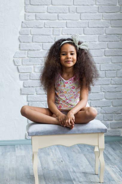 istock Cute afro girl against the gray wall 821562730
